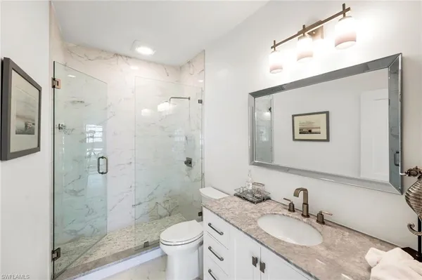 a bathroom with a granite countertop sink toilet a shower and a mirror