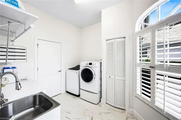 a bathroom with a granite countertop sink and a washing machine