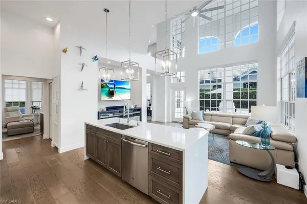 a kitchen with stainless steel appliances granite countertop a sink a stove and a wooden floors