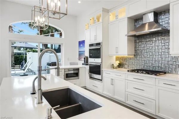 a kitchen with granite countertop a sink stainless steel appliances and cabinets