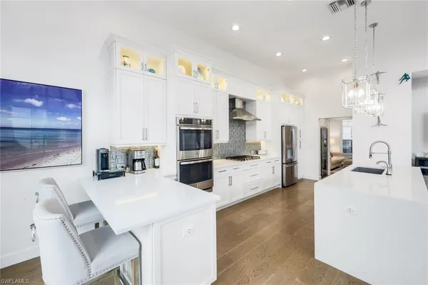 a kitchen with stainless steel appliances kitchen island granite countertop a sink and refrigerator