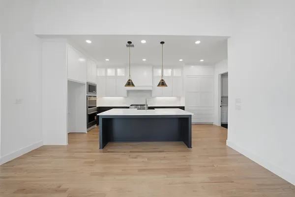 a kitchen with kitchen island a sink stainless steel appliances and cabinets