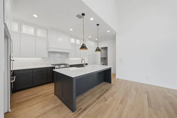 a large room with kitchen island a sink wooden floor and view living room