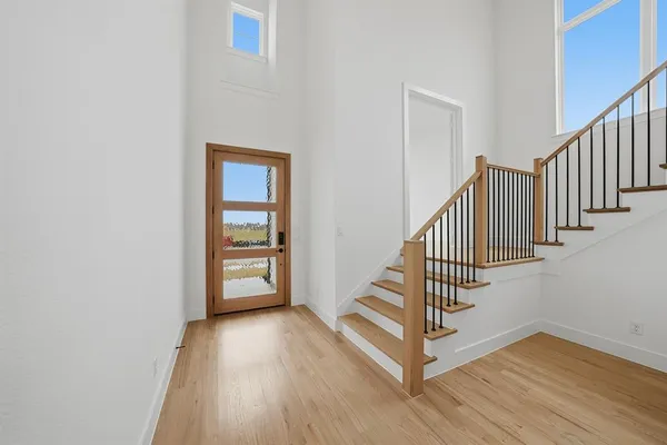 a view of a hallway with wooden floor and staircase