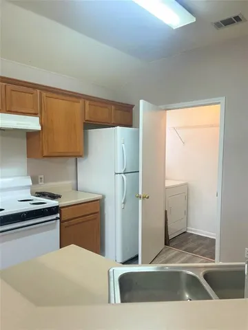 a kitchen with a refrigerator sink and cabinets