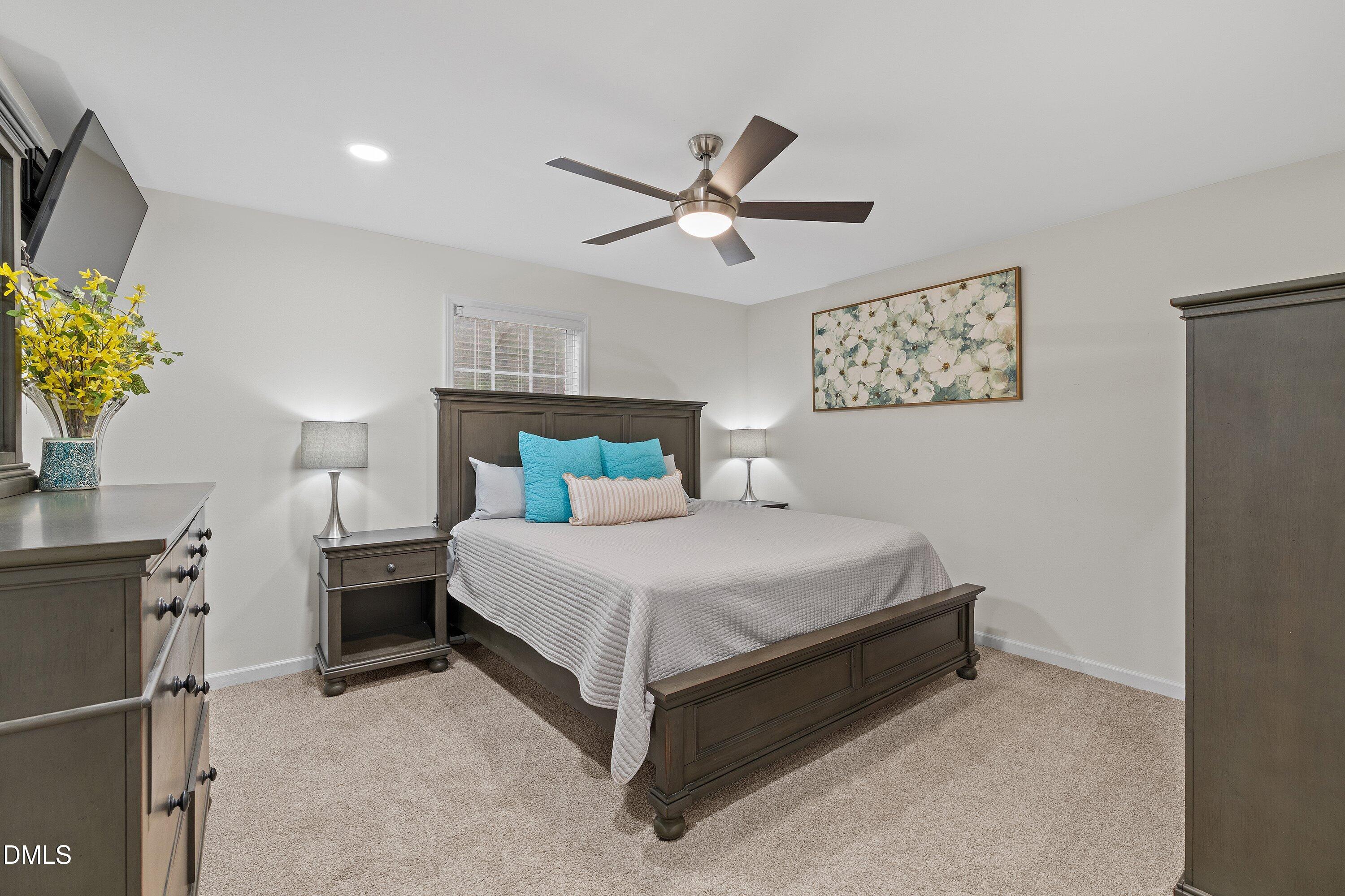 234 Linville Lane Willow Spring, NC 27592 - Photo 15 of 34 a bedroom with a bed and a chandelier