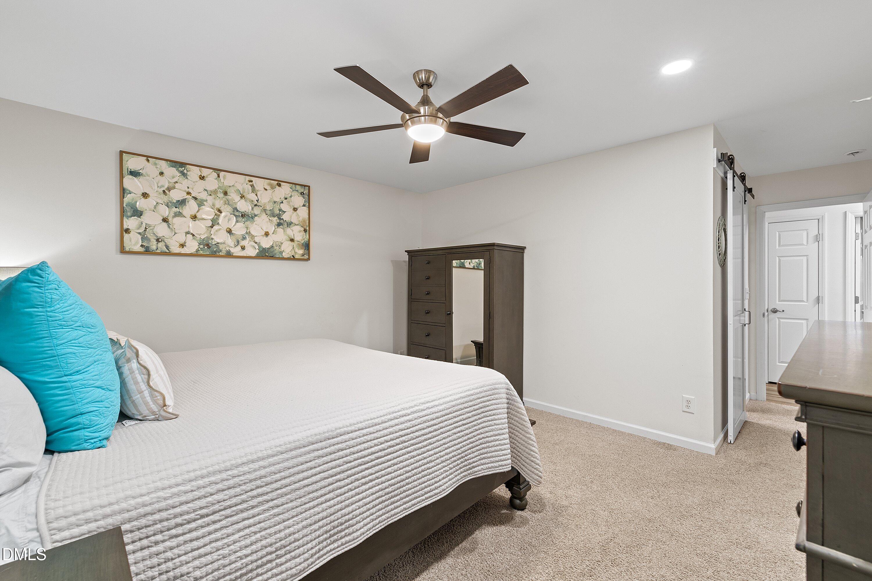 234 Linville Lane Willow Spring, NC 27592 - Photo 16 of 34 a bedroom with a large bed and a ceiling fan