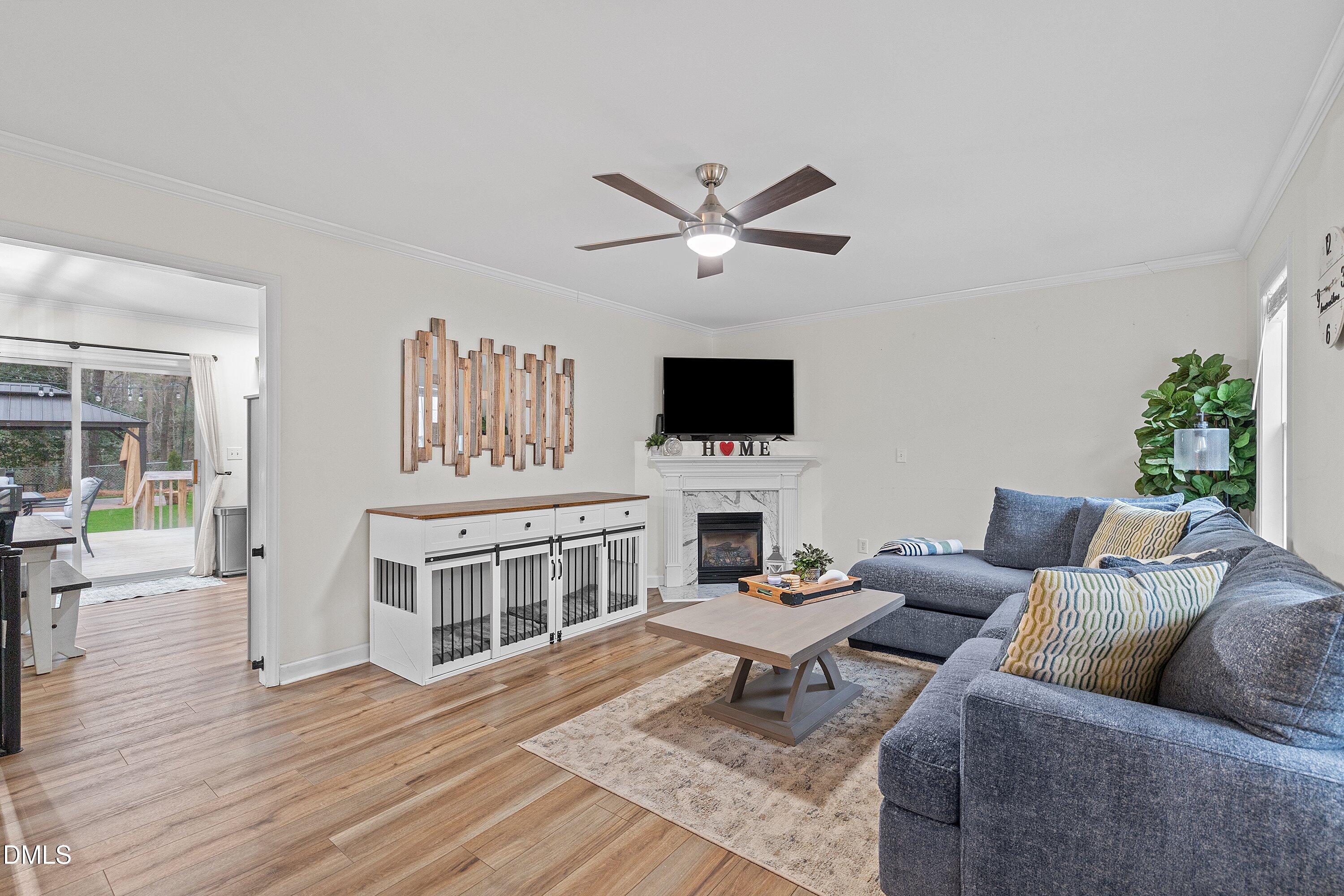 234 Linville Lane Willow Spring, NC 27592 - Photo 8 of 34 a living room with furniture a fireplace and a flat screen tv
