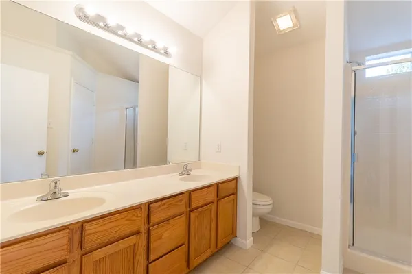 a bathroom with a double vanity sink mirror and toilet