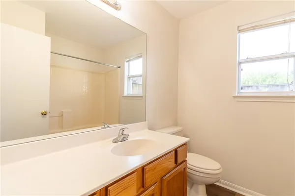 a bathroom with a sink a toilet and a window