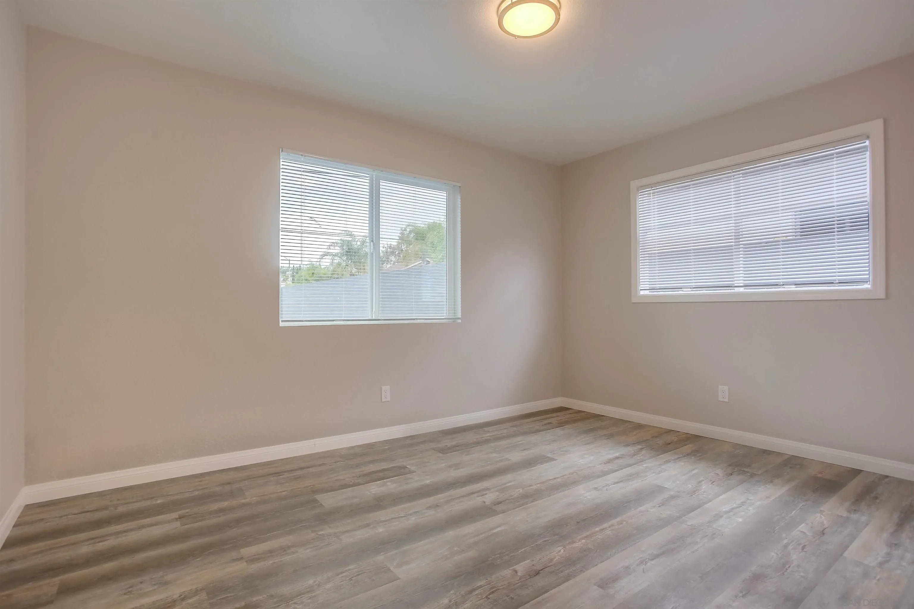 1055 Old Stage Road Fallbrook, CA 92028 - Photo 7 of 16 an empty room with wooden floor and windows