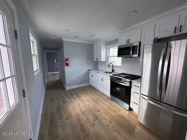 a kitchen with stainless steel appliances a refrigerator sink and microwave