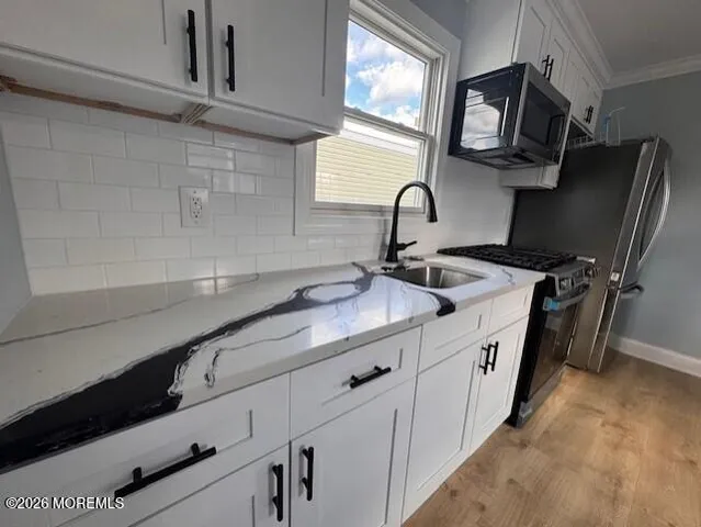 a kitchen with stainless steel appliances sink a microwave and cabinets