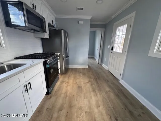 a kitchen with stainless steel appliances a stove top oven a sink and a refrigerator