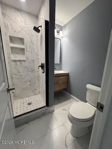 a white toilet sitting next to a bathroom sink