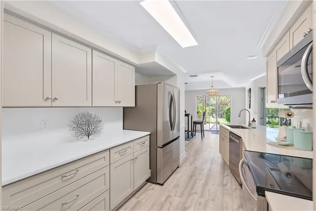 a kitchen with stainless steel appliances white cabinets and wooden floors