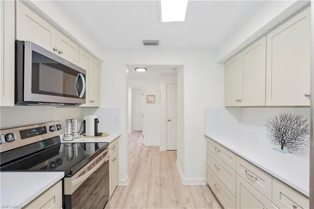 a kitchen with stainless steel appliances a stove microwave and cabinets
