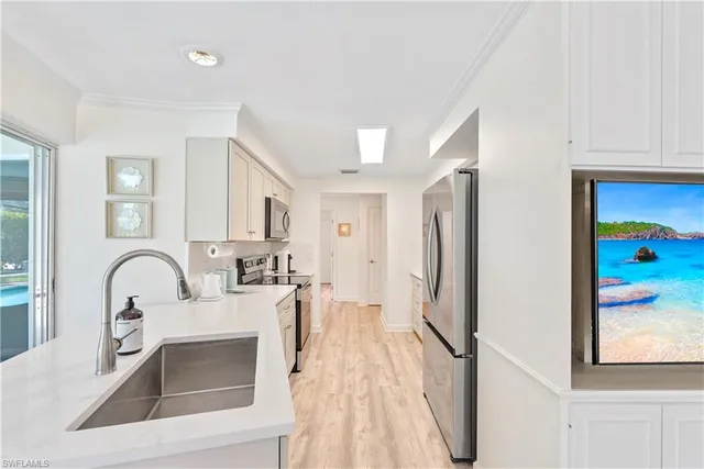 a kitchen with stainless steel appliances granite countertop a refrigerator and a sink