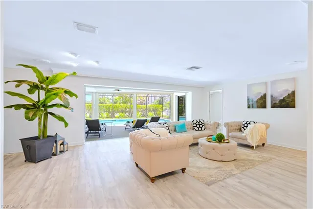 a living room with furniture potted plant and a large window
