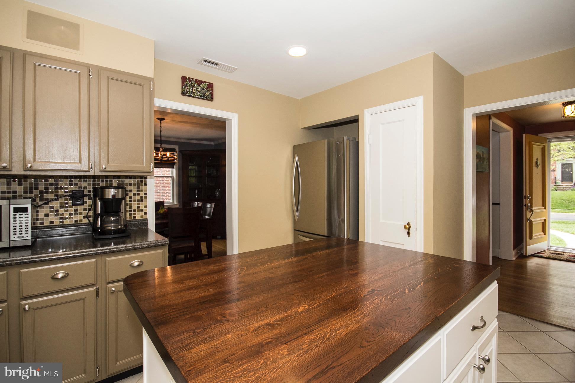 623 Overbrook Road Baltimore, MD 21212 - Photo 9 of 30 a kitchen with stainless steel appliances granite countertop a refrigerator a stove and white cabinets with wooden floor