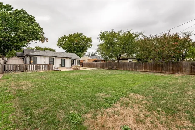 a view of house with yard and trees in the background