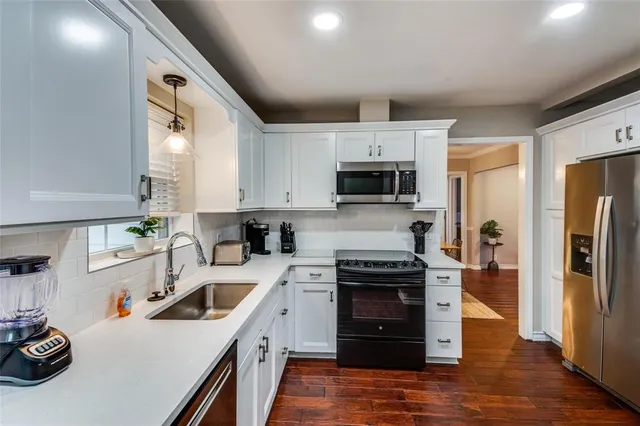 a kitchen with a sink a stove and refrigerator