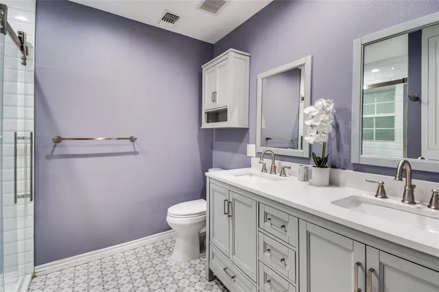 a bathroom with a granite countertop sink a toilet and a mirror