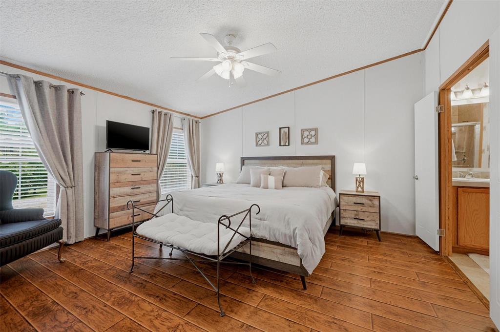 212 Sunset Road Pottsboro, TX 75076 - Photo 13 of 40 a bedroom with a bed and a flat screen tv