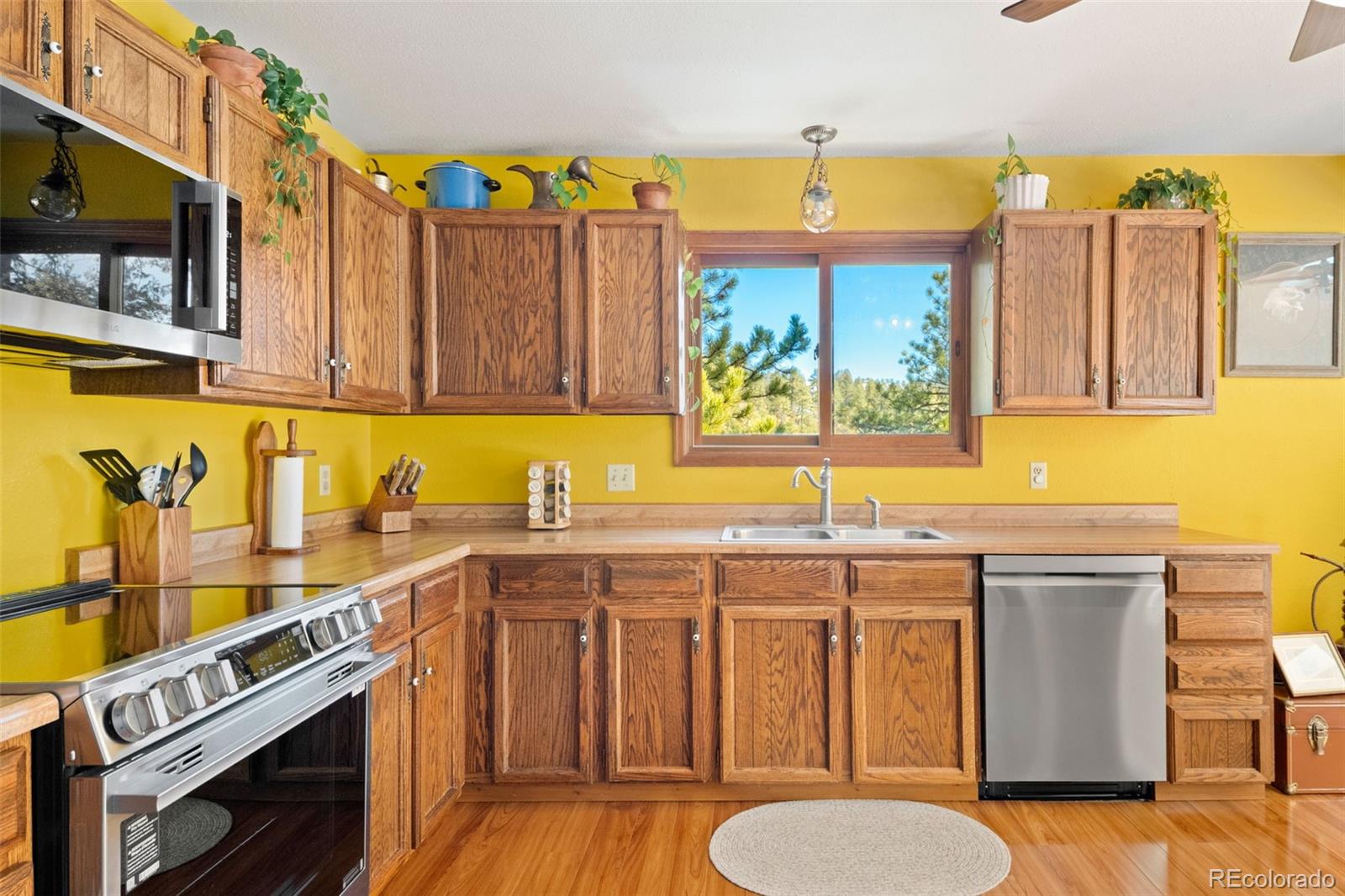1269 Roland Drive Bailey, CO 80421 - Photo 18 of 38 a kitchen with a sink a stove and wooden cabinets