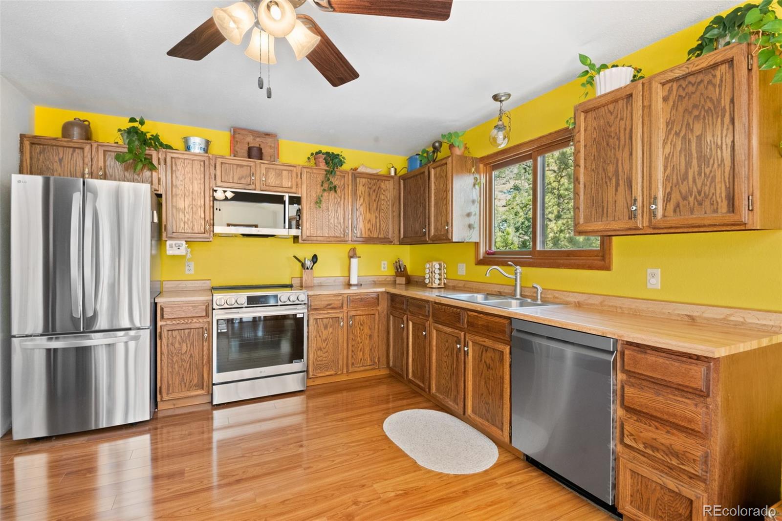 1269 Roland Drive Bailey, CO 80421 - Photo 19 of 38 a kitchen with stainless steel appliances granite countertop a sink a stove a refrigerator cabinets and wooden floor