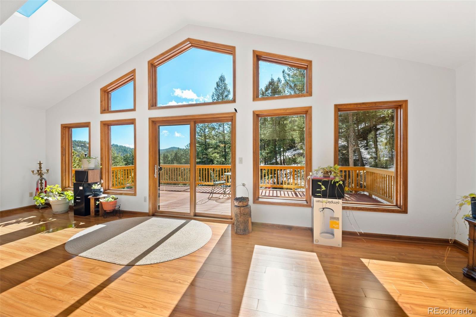 1269 Roland Drive Bailey, CO 80421 - Photo 7 of 38 a spacious bedroom with a large window and a balcony