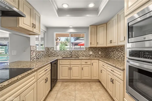 a kitchen with stainless steel appliances granite countertop a sink stove and microwave