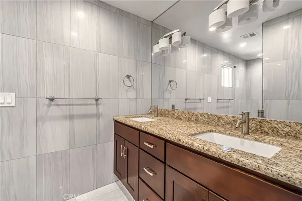 a bathroom with a granite countertop sink a shower and a mirror