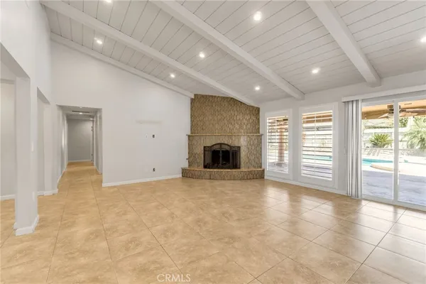 an empty room with windows and fireplace