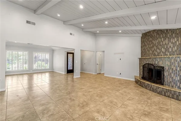 a view of an empty room with a fireplace and a window