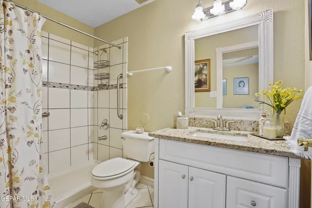 a view of a backyard with large trees and wooden fence