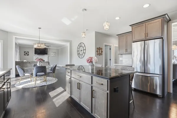 a kitchen with stainless steel appliances granite countertop a sink refrigerator and cabinets
