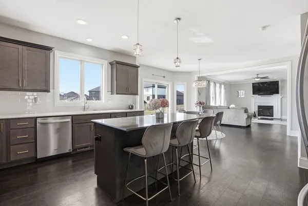 a kitchen with stainless steel appliances granite countertop a stove a sink a kitchen island with a dining table and chairs