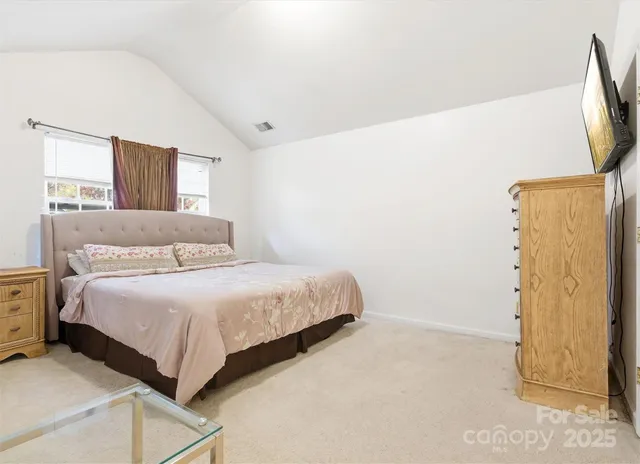 a bedroom with a bed and a refrigerator