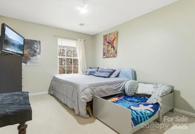 a bedroom with bed and a flat screen tv