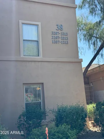a view of a yard with plants and a bench