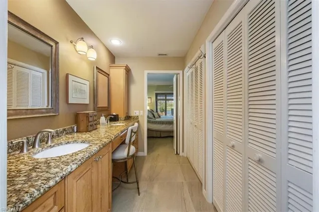 a en suite bathroom with a granite countertop sink and a mirror