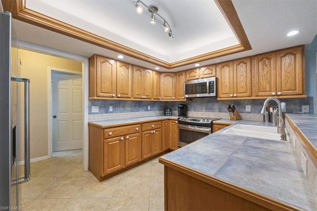 9534 Campbell Circle Naples, FL 34109 - Photo 9 of 31 a kitchen with stainless steel appliances granite countertop a sink stove and microwave