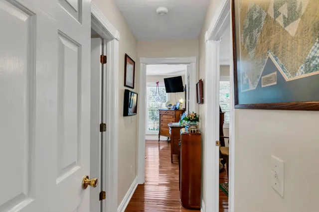 a view of a hallway with wooden floor and staircase