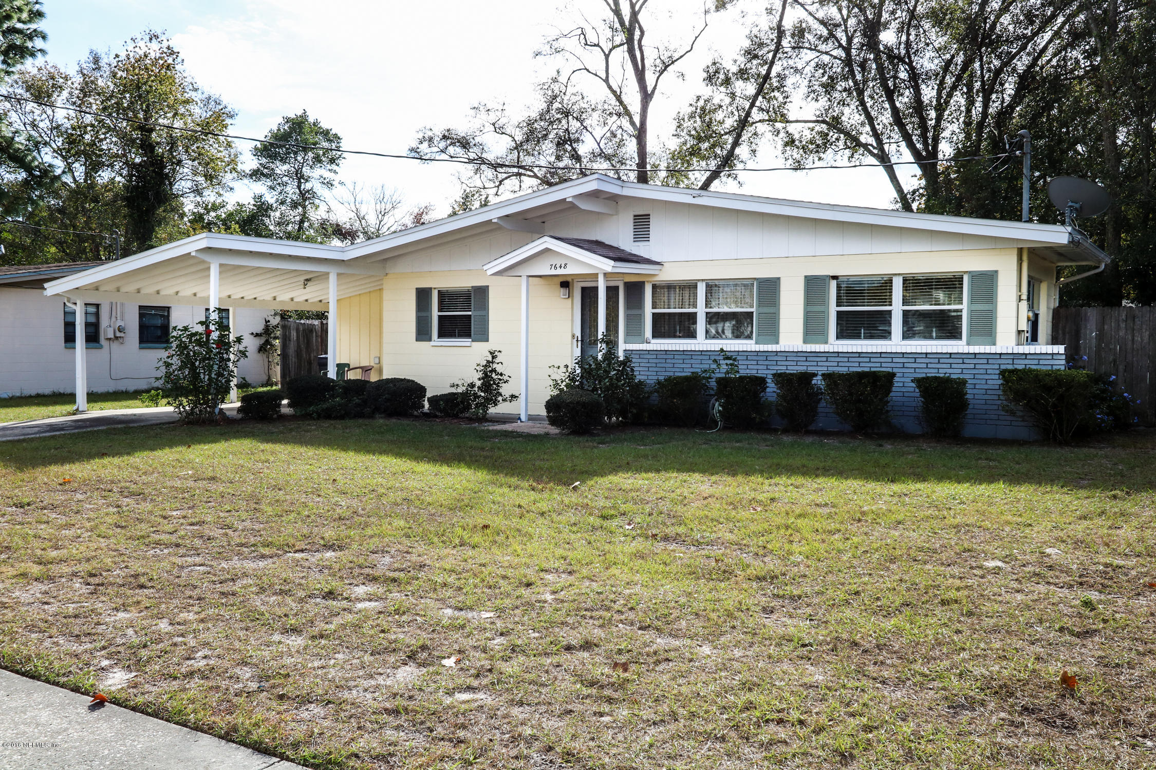 a front view of a house with a garden and trees