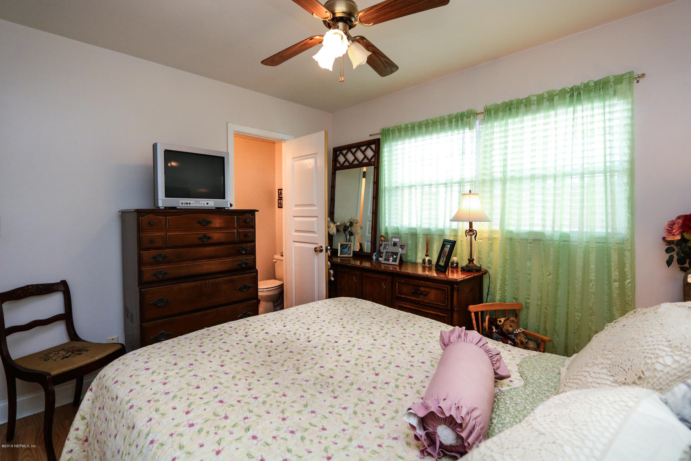 7648 Rambler Road Jacksonville, FL 32244 - Photo 18 of 29 a bedroom with a bed and wooden floor