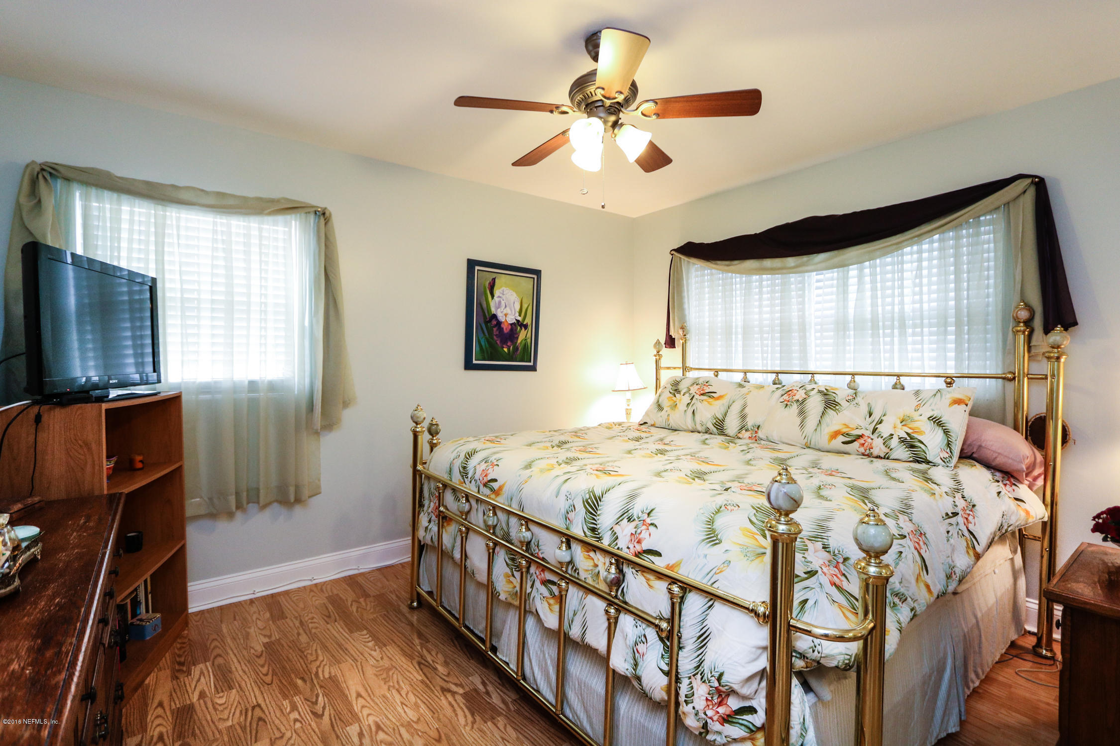 7648 Rambler Road Jacksonville, FL 32244 - Photo 20 of 29 a bedroom with a bed a window and a flat screen television