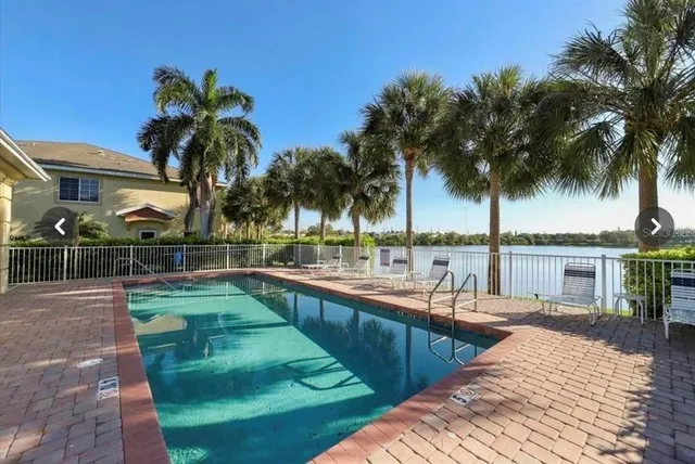 a view of a swimming pool with a patio and a yard