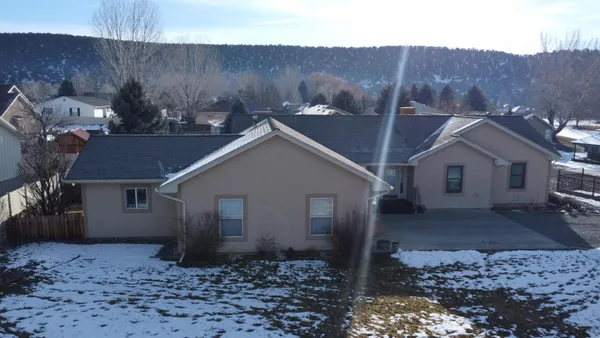 a view of a house with a yard and large tree