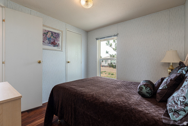 740 Riddle Drive Fredonia, AZ 86022 - Photo 13 of 20 Bedroom featuring wood-finish flooring, textured wall panels, and a ceiling-mounted light fixture
